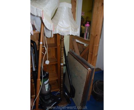 A standard lamp with cream fringe shade.