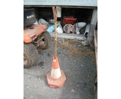 Two road cones and a walking stick with hand-like top.