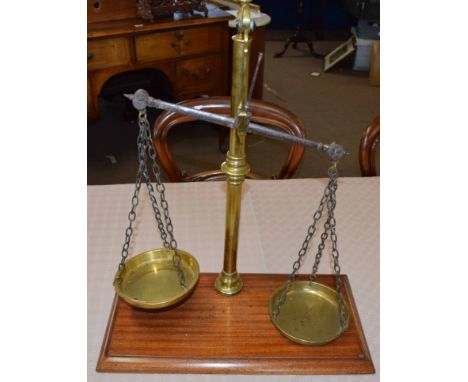 Set of vintage brass beam scales on a mahogany plinth, 48cm wide