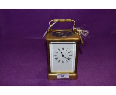 A brass cased carriage clock having enamel face dial and bevel edged glass with chime