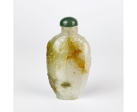 A Chinese carved mixed colour jade snuff bottle decorated with flowers and foliage, H. 7.5cm.