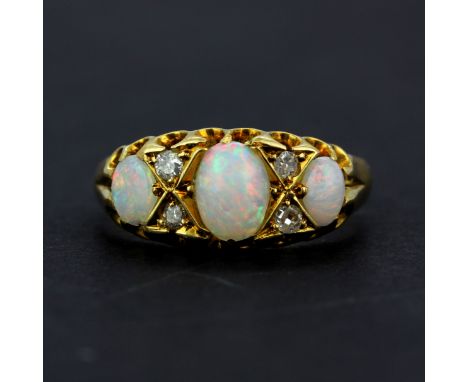 A hallmarked 18ct yellow gold ring set with oval cabochon opals and diamonds, (N), gross weight approx. 3.2gr.&nbsp;