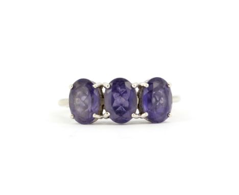 A hallmarked 9ct white gold ring set with oval cut tanzanites, (M.5).