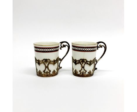A pair of hallmarked silver cup holders with Royal Worcester porcelain liners, H. 6.1cm. One cup is A/F.
