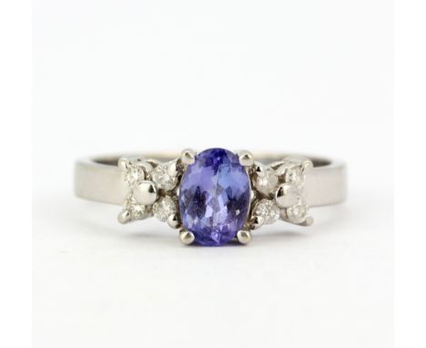 A 14ct white gold (stamped 14K) ring set with an oval cut tanzanite and diamonds, (P.5).