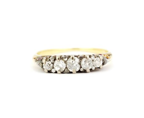 A yellow metal (tested high carat gold) ring set with graduated old cut diamonds, (S.5).