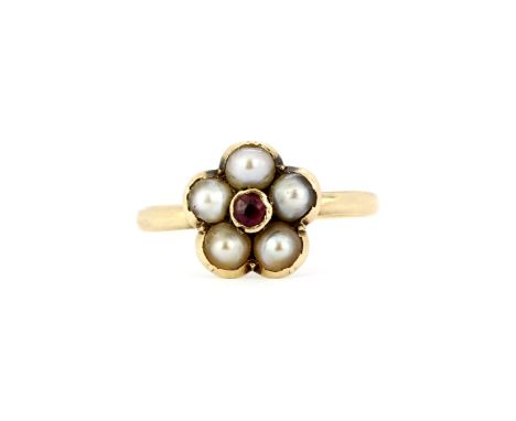 A boxed yellow metal (tested minimum 9ct gold ring) flower shaped ring set with a garnet and seed pearls, (P). Slight bend to