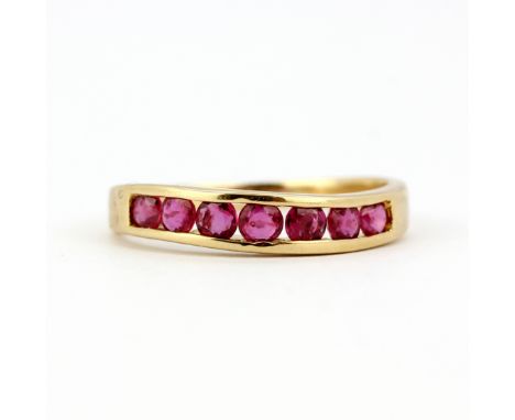 A 14ct yellow gold ring channel set with round cut rubies, (L.5).