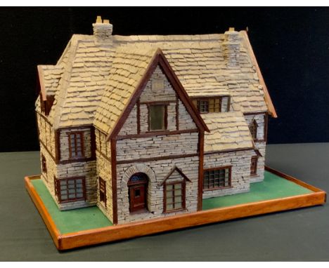 A stone built two storey cottage form table lamp, illuminated windows, 31cm high, 45cm, long, 33cm deep 