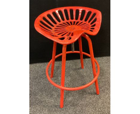 A retro ‘tractor-seat’ metal stool, painted red, rise-and-fall swivel seat, 68.5cm high. 