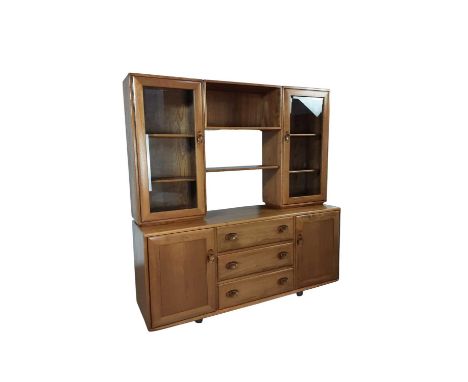 ERCOL WINDSOR LIGHT ELM DISPLAY CABINET, with two glazed side cupboards with central shelf unit, on a base with three drawers