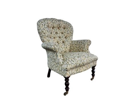 BUTTON BACK ARMCHAIR, BY STUART JONES with leaf design fabric on turned mahogany legs and brass castors93cm high
