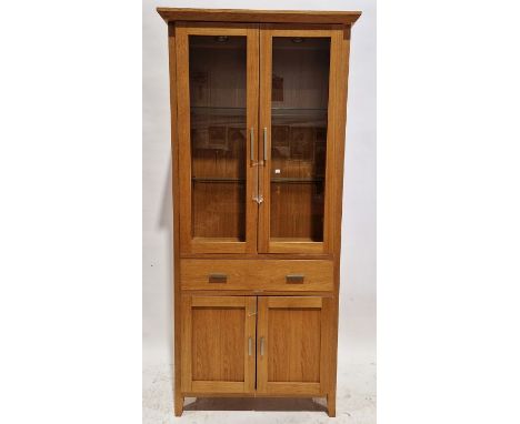 Morris Furniture light oak display cabinet, the top section having two glazed doors opening to reveal two fitted glass shelve