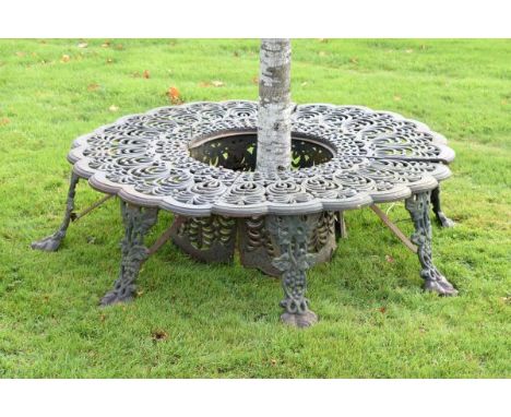 Cast iron circular tree seat made in four sections, the top decorated with pierced palmettes, the eight supports with bunches