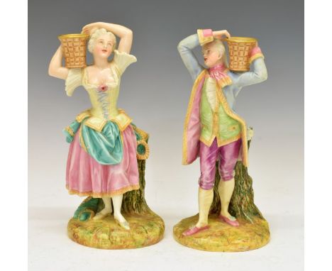Pair of late 19th Century Royal Worcester figural candlesticks formed as a young gallant and lady, each with a wicker basket 