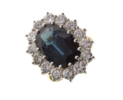 Sapphire and diamond cluster ring, in 18ct gold, the sapphire approximately 14.2mm x 9.6mm x 5mm deep, enclosed by fourteen b