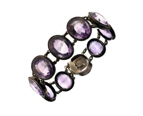 Amethyst bracelet, the nine graduated oval cut stones in unmarked silver coloured metal, 15.5cm long  Condition: The central 