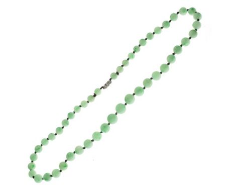 Graduated row of jade beads, to a three stone diamond set clasp, the forty-seven beads of approximately 6.6mm to 9.4mm diamet