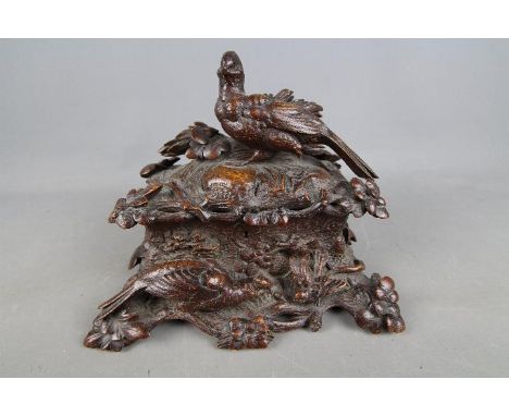 A Black Forest oak Tea Caddy of rectangular form, profusely carved with depictions of exotic birds perched upon branches with