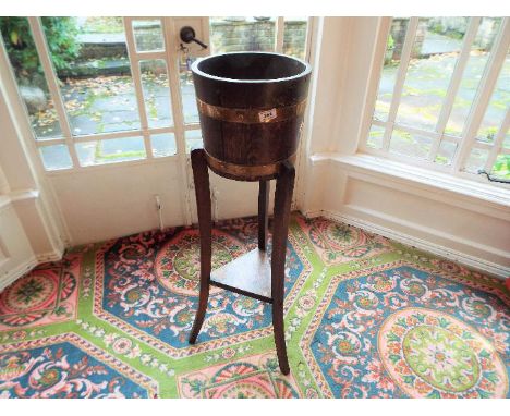 A 19th century coopered oak and brass bound barrel planter / plant stand torchere raised on shaped supports with triangular l