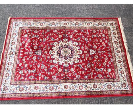 A red ground Kashmir carpet / rug with medallion pattern, approximately 240 cm x 160 cm. Est £200 - £300