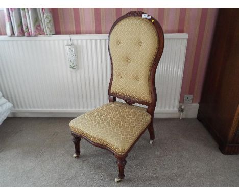 A button back nursing chair, the supports terminating in casters, beige upholstery, 100 cm (h) 
