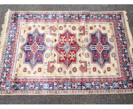 A cream ground Kashmir carpet / rug with an Aztec style design, approximately 240 cm x 160 cm. Est £200 - £300