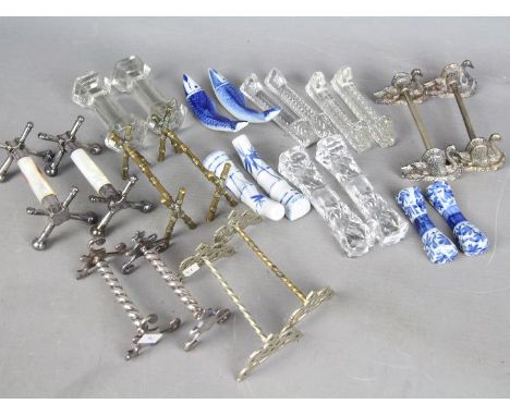 Twelve pairs of knife rests to include silver plated, cut glass, blue and white ceramic examples. Est £30 - £40