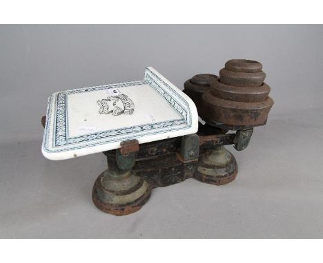 A set of cast iron and ceramic scales by Reuben Sutcliffe, Manchester and a quantity of weights. £30 - £40
