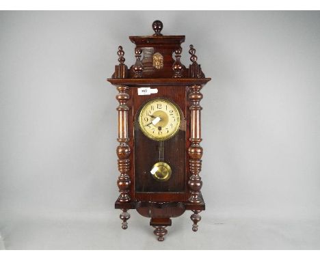 A small wall clock with key and pendulum.