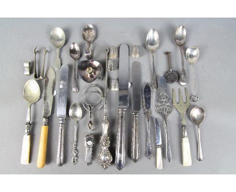 A collection of silver and white metal items to include three silver thimbles, silver sugar spoon, silver handled button hook