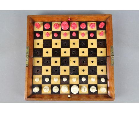A Jaques & Son 'In Statu Quo' travelling chess set with natural and red stained pieces, locking and release mechanism functio