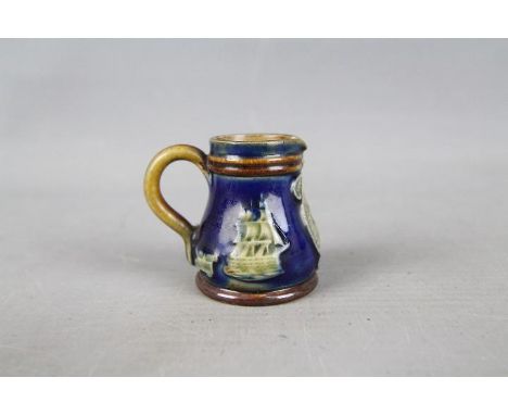 Royal Doulton - A miniature Royal Doulton stoneware commemorative jug with green glazed portrait of Lord Nelson and HMS Victo