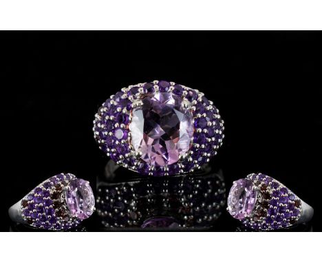 Amethyst and Rhodolite Garnet Dome Ring, an oval cut 4.5ct solitaire amethyst set above a domed ring, pave set with a single 