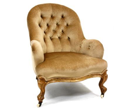 A BEIGE DRAYLON AND WALNUT FRAMED BUTTON BACK TUB CHAIR on casters, 88cm high