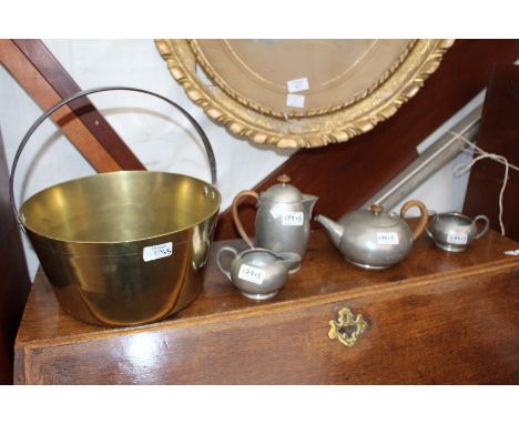 A BRASS JAM PAN and a four piece beaten pewter tudric tea set consisting of a tea pot, a coffee pot, sucrier and cream jug