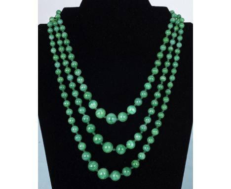 A three strand spinach jade necklace with jade cabouchon clasp, longest strand 52cm