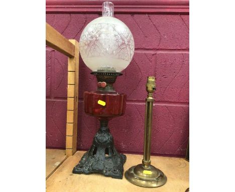 Brass oil lamp with cranberry reservoir, together with three stylish early 20th century lamps (4)