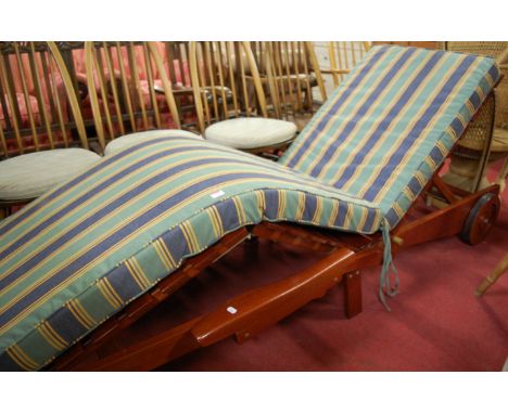 A contemporary hardwood sun lounger, having a hinged action with striped cushion seat