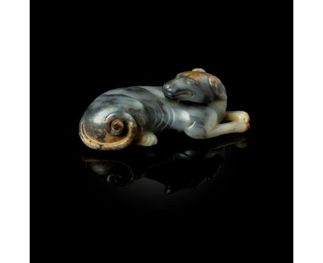  CHINESE WHITE AND BLACK JADE CARVING OF A RECUMBENT DOG QING DYNASTY 清 青花料玉雕狗形擺件carved as a slender recumbent dog with its h