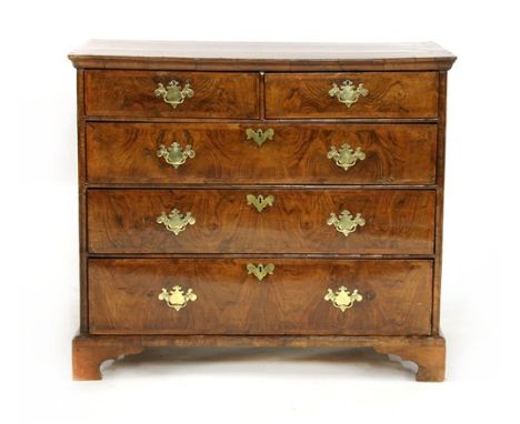 A Queen Anne figured walnut chest, of two short and three long drawers, with a quarter veneered crossbanded top, later handle