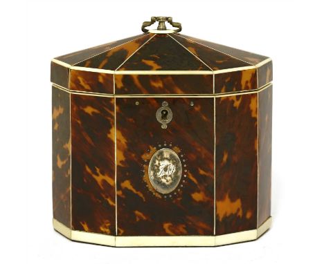 A George III tortoiseshell single compartment tea caddy, of long decagonal shape with ivory borders and an oval white metal p