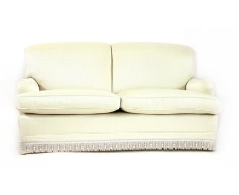 A modern two-seater settee, by Howard Chairs Ltd., with light grey upholstery on square tapering legs and brass castors, stam