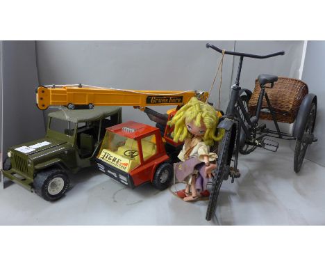 A Tonka Toy Jeep, a die-cast metal crane, a model of a tricycle and a puppet 