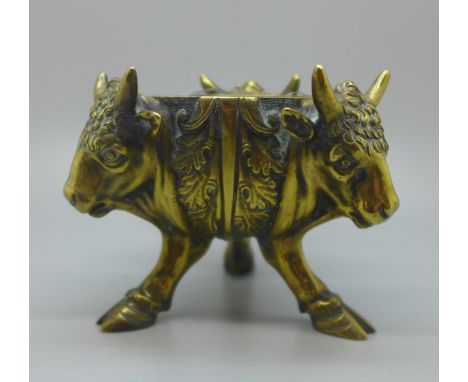 A cast brass inkwell with three bull's heads and feet 