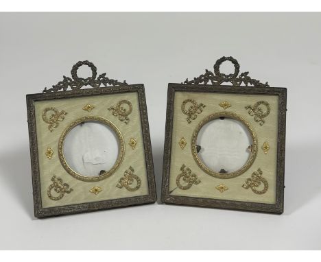 A pair of Edwardian gilt-metal photograph frames, each square frame with ribbon-tied wreath surmount, square, the circular ap
