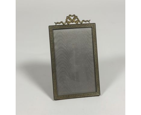 An Edwardian gilt-metal photograph frame, the rectangular aperture within a ribbon-bound reeded frame beneath a bow surmount,