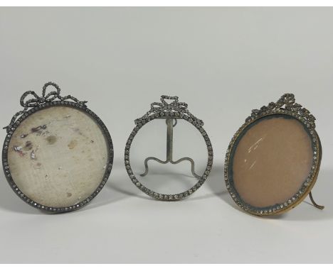 A group of three paste "gem-set" photograph frames, early 20th century, each circular and with ribbon-tied surmount, easel ba