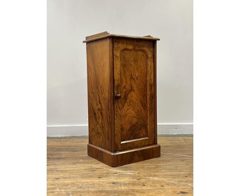 A well figured Victorian walnut bedside cabinet, the 3/4 galleried top over single arch panelled door enclosing a fixed shelf
