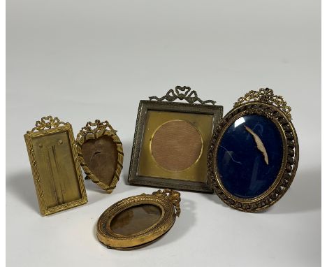 A group of small Edwardian gilt-metal photograph frames comprising: a square frame with ribbon-tied surmount; two oval frames